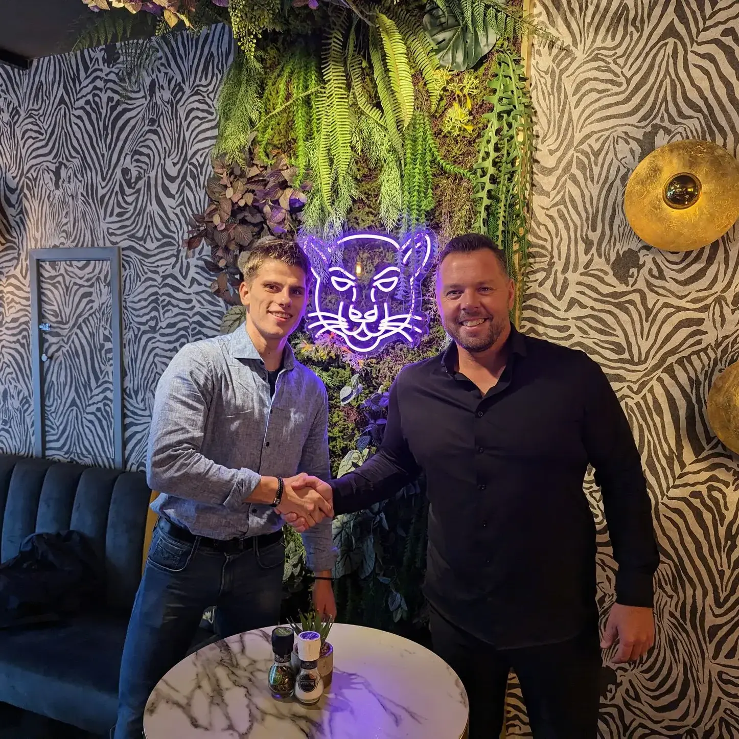 Accountmanager van SPOT Energie en horecaondernemer van Friet Panters Breda schudden handen in hun restaurant na succesvol energieadvies van SPOT Energie